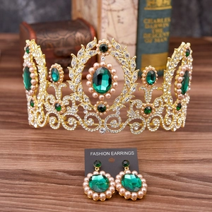Detailed macro of Baroque gold crown and earrings set with green stones and pearls