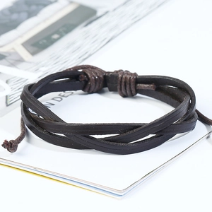 Macro shot of dark brown multi-strand braided leather bracelet on a white book page