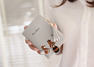 Close-up of gray short wallet with cute fox embroidery and decorative tassel detail