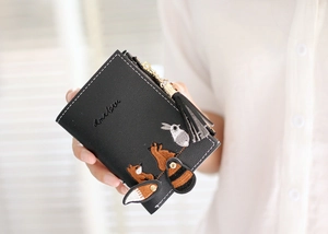 Close-up of black PU leather wallet with animal embroidery, tassel zipper and metal chain