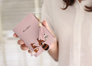 Detailed embroidery of a cute animal and tassel zipper on a pink bifold wallet