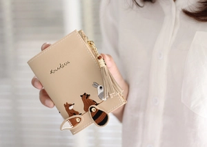 Detail of beige PU leather wallet with cute fox embroidery and tassel pendant zipper