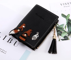Close-up of black bifold wallet with cute fox embroidery and decorative tassel detail
