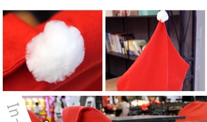 Detail of red Christmas chair cover with white fluffy pom-poms and thick fabric texture