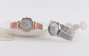 Close-up of elegant women's quartz watches with marble texture dials and mesh bands
