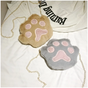 Close-up of plush cat paw crossbody bags in grey and brown with golden metal chains