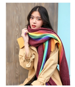 Detailed texture of rainbow striped knit scarf with soft tassel edges on coat