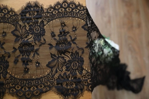 Close-up of black eyelash lace fabric with intricate floral embroidery for table runners