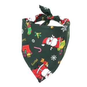 Detail of green Christmas pet bandana featuring Santa and snowflake prints on cotton fabric