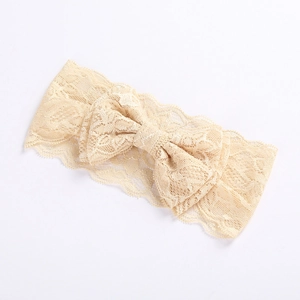 Close-up of wide beige lace headband featuring a large bow for baby girls