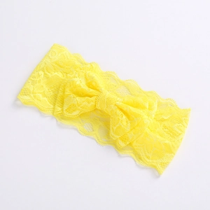 Macro shot of yellow lace fabric texture and bow detail on the baby girls headband