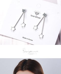 Detail view of silver star drop earrings featuring crystal studs and long double chains