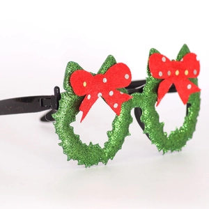 Close-up of Christmas party glasses with green glitter wreath frame and red polka dot bow