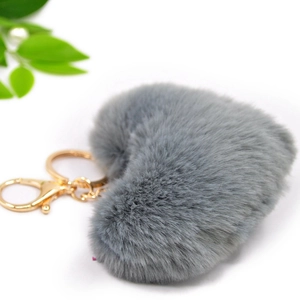 Detailed view of a soft grey plush heart keychain with premium gold-tone metal hardware
