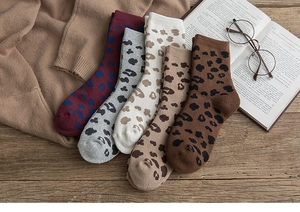 Detail of five pairs of thick winter leopard print crew socks in autumn warm tones