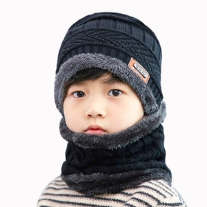 Detail of black knit winter hat for kids with thick grey faux fur lining for extra warmth