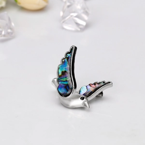 Exquisite bird brooch featuring colorful natural abalone shell wings on silver metal base
