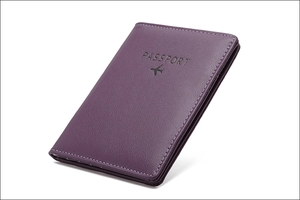 Close-up of purple PU leather RFID passport holder with airplane and passport embossed design
