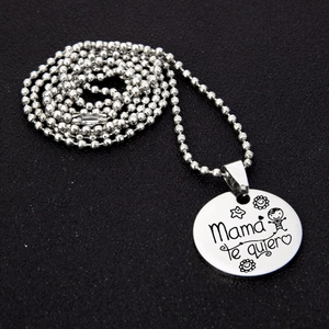 Détail macro du collier en acier inoxydable avec texte gravé Mama te quiero