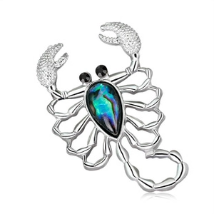 Silver scorpion brooch with colorful abalone shell and black gemstone eyes on white background