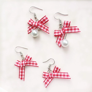 Japanese style red plaid bow earrings with white faux pearls on a clean background