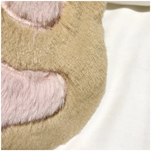 Detailed close-up of soft brown and pink faux rabbit fur texture on cat paw bag