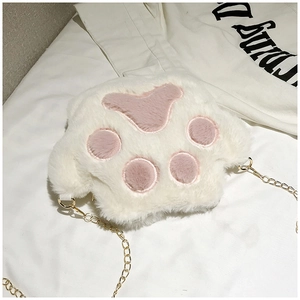 Close-up of fluffy white cat paw plush crossbody bag with soft pink paw pads and gold chain