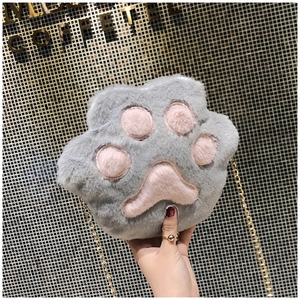 Macro detail of fluffy plush cat paw crossbody bag with golden chain and soft grey fur