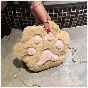 Close-up of fluffy plush cat paw shoulder bag with pink pads and gold chain