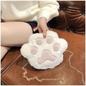 Close-up of white plush paw-shaped crossbody bag with pink paw pad and gold chain strap