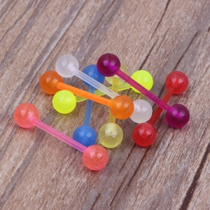 Bunte Zungenpiercings aus Acryl im Set, ungiftig und UV-leuchtend auf Holzuntergrund