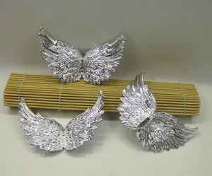 Detailed view of silver angel wing accessories with intricate feather textures for DIY crafts