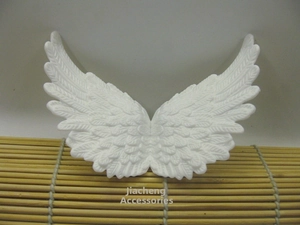 Close-up of white embossed fabric angel wings with detailed feather texture pattern