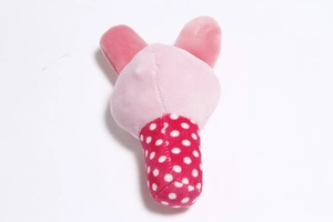 Detailed back view of pink plush pet toy with red polka dot fabric pattern on white background