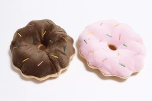 Detail of plush donut pet toys in brown and pink with colorful embroidery patterns