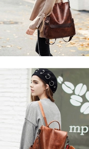 Detail of vintage brown faux leather backpack with stylish orange pompom accessory