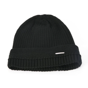 Detail of ribbed knit winter hat featuring a silver metal plate with Classic lettering
