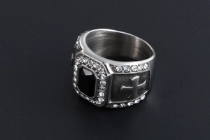 Gros plan d'une bague vintage en argent avec gemme noire et motifs de croix