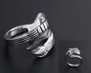Macro detail of vintage guitar-shaped stainless steel ring with intricate metallic textures