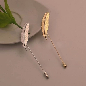 Detail of silver and gold feather lapel pins with realistic metallic vein textures