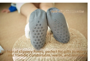 Detail of gray knitted thermal slipper socks with thick fleece lining and non-slip soles