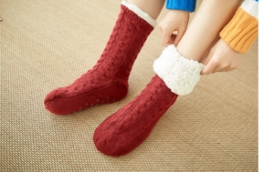 Detail of red cable knit floor socks with plush fleece lining and non-slip bottom soles