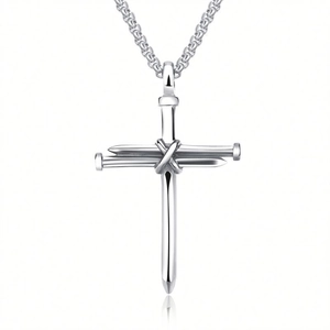 Detailed view of silver cross pendant made of intertwined nails on a polished metal chain