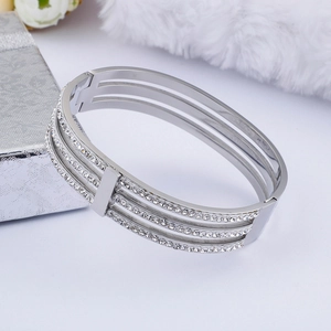 Modern triple-layered hollow silver bangle with pave rhinestones on a white plush mat