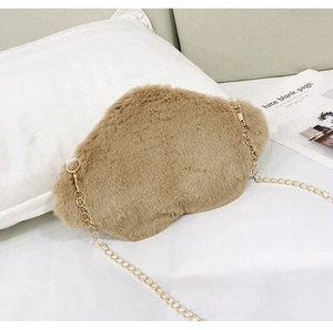 Detail of soft khaki plush cloud bag with elegant gold metal chain strap on white bedding