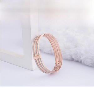 Detail of three-layer rose gold bracelet with crystal inlay on a display stand