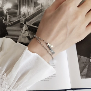 Detail of S925 sterling silver tassel bracelet with layered chains on a fashion magazine