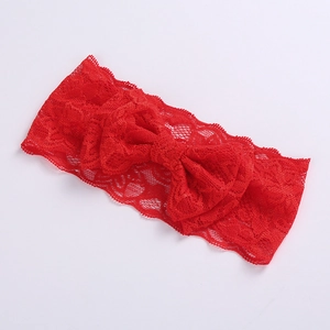 Detail of red lace headband with a large bow showing soft texture for babies and girls