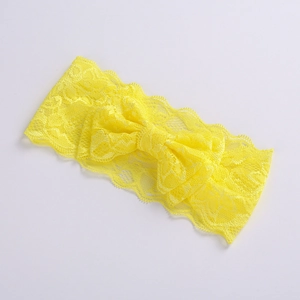 Detailed macro view of bright yellow double-layer lace bow headband for baby girls