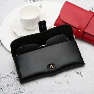 Leather sunglasses case in black and red with lychee texture and gold button closure